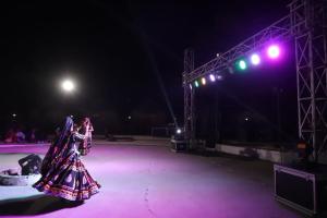 Twee mensen dansen 's nachts op een podium. bij Royal Rangers Desert Safari Camp in Jaisalmer