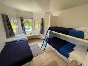 a bedroom with two bunk beds and a ladder at Villa Grecia-Villas del Pacifico in San José de Guatemala