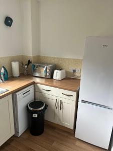 a kitchen with a white refrigerator and a trash can at Luxury Rooms And An En-Suite Room With Free WI-FI Clarendon Way in Colchester