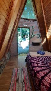 a bed in a room with a large window at NOMADAS chales, mini casinhas, bangalôs e area de camping in Bonito +54 photos