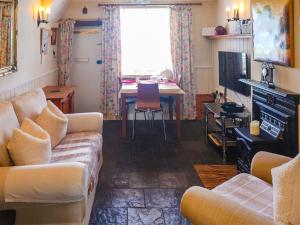 un soggiorno con divano e tavolo di Tanners Cottage a Cockermouth