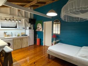 Rivière-Salée的住宿－Charmant bungalow avec petite piscine privée，一间卧室设有一张床和蓝色的墙壁