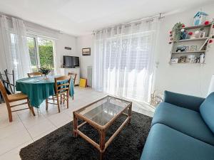 sala de estar con sofá azul y mesa en Appartement Donville-les-Bains, 2 pièces, 2 personnes - FR-1-361-442, en Donville-les-Bains