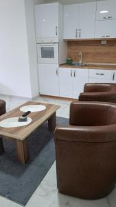 eine Küche mit einem Holztisch und 2 Stühlen in der Unterkunft Apartman Dzejda in Novi Pazar
