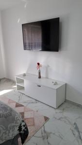 - un salon blanc avec une télévision murale dans l'établissement Apartman Dzejda, à Novi Pazar