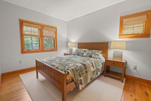a bedroom with a bed and a table with a lamp at Spacious Ski Haven Pool Table Grand Fireplace! in Lincoln