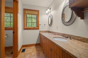a bathroom with a sink and a mirror at Spacious Ski Haven Pool Table Grand Fireplace! in Lincoln +55 photos