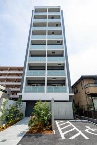 wysoki budynek z parkingiem przed nim w obiekcie HOTEL KOU Haruyoshi - Vacation STAY 43463v w mieście Fukuoka