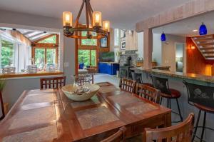 a kitchen and dining room with a wooden table and chairs at Loon Mtn Pool Hot Tub Firepit Sleeps 17 in Lincoln