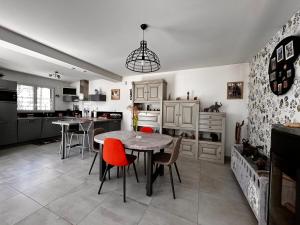 uma cozinha com mesa e cadeiras e uma cozinha com balcão em Maison Saint-Brevin-les-Pins, 4 pièces, 5 personnes - FR-1-364-168 em Saint-Brévin-les-Pins