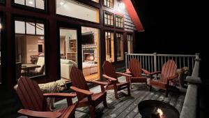 um alpendre com cadeiras de baloiço e uma lareira em Stunning Mountain Views Game Room Sleeps 16 em Lincoln