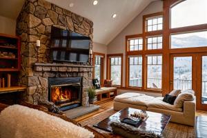 a living room with a large stone fireplace at Stunning Mountain Views Game Room Sleeps 16 in Lincoln
