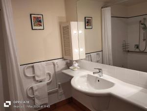 a white bathroom with a sink and a mirror at The Bruce Waterfront Apartments by AVI in Akaroa