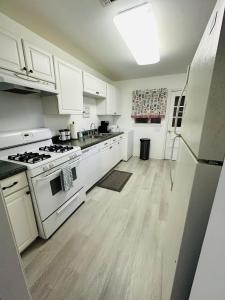 a kitchen with white appliances and wooden floors at Feels like HOME escape, 1/2 Mile to beach in Gulfport