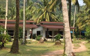 a house with palm trees in front of it at Rim Lay in Ko Kood