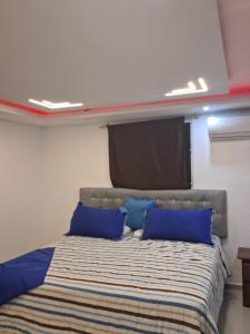 uma cama com almofadas azuis num quarto em PARADISE S 111 em Santiago de los Caballeros