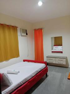 a bedroom with a bed with an orange curtain at Wjv Inn Talamban in Cebu City