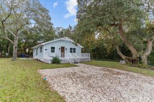 una casa blanca en medio de un patio en The Blue Wave Quiet & Cozy Beach Retreat, en Oak Island