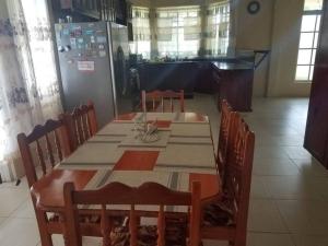 a dining room with a table and chairs and a piano at The Essence of Quiet and Comfort in Roseau +7 photos