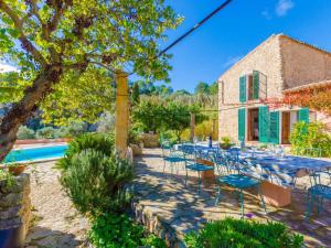 un patio con mesas y sillas junto a una casa en Sobreamunt - Villa With Private Pool In Esporles Free Wifi, en Puigpunyent