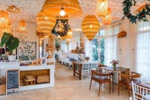 a restaurant with tables and chairs and chandeliers at Pupah Kanna Pua-ปู๋ ป๋าล์ คันนา ปัว in Pua