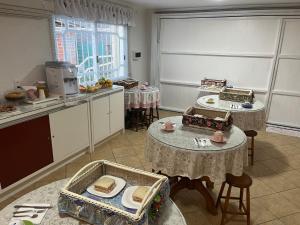 a kitchen with two tables and two tables with food at Casa da Fabi in Gramado