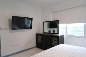 a bedroom with a flat screen tv on the wall at Chateau Apartment in New Kingston