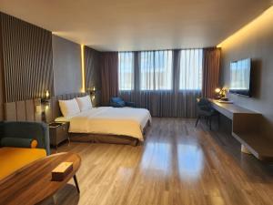 花蓮市にある花蓮品悅文旅Hualien Pink Corner Hotelのベッドとデスクが備わるホテルルームです。