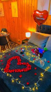 uma cama com um sinal de coração e um balão em Chalé Geburt em Monte Verde