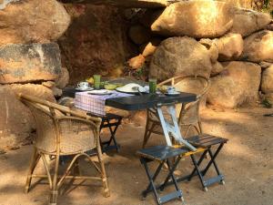 a table with two chairs and a table with food on it at RedBrick House Rumassala in Galle +21 photos