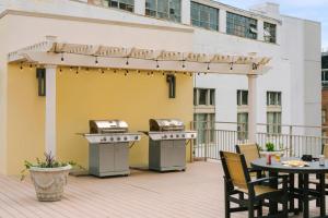 a patio with a grill and tables on a balcony at Roami at Duncan Plaza in New Orleans