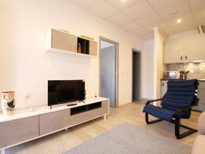 Apartamento Los Alcázares, 1 dormitorio, 3 personas - ES-220-54 في توري-باتشيكو: غرفة معيشة فيها تلفزيون وكرسي ازرق