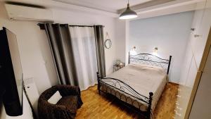 a bedroom with a bed and a chair in it at Freatida apartment in Piraeus