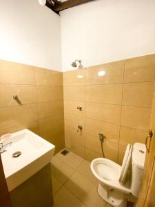 a bathroom with a toilet and a sink at RedBrick House Rumassala in Galle