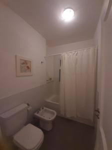 Baño blanco con aseo y lavamanos en Terrazas de Carilo 1C en Cariló