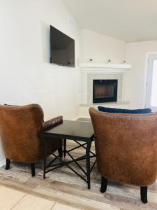 a living room with two chairs and a table and a fireplace at Casa Feliz Arizona in Fort Mohave