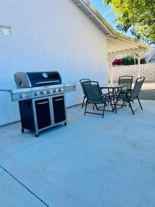 a grill with chairs and a table on a patio at Casa Feliz Arizona in Fort Mohave