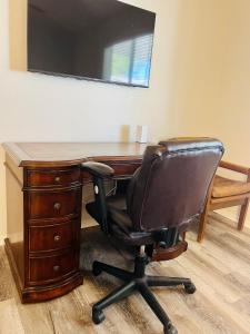 an office with a desk with a chair and a television at Casa Feliz Arizona in Fort Mohave