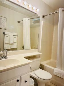 a bathroom with a sink and a toilet and a mirror at Casa Feliz Arizona in Fort Mohave