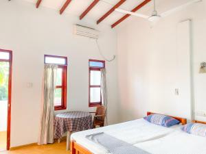 a bedroom with two beds and a table and chairs at Summer lodge-Tangalle in Tangalle