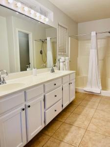 a bathroom with two sinks and a large mirror at Casa Feliz Arizona in Fort Mohave