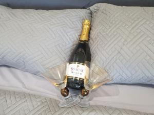 una bottiglia di vino seduta su un letto con un bicchiere di Ocean View Utopia a Cooperʼs Town