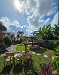 a garden with a table and two chairs and a table at The Lucky Canggu 2 in Canggu