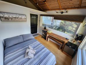 a bedroom with a bed and a bench and a window at Madeira Park Oceanview Suites in Madeira Park