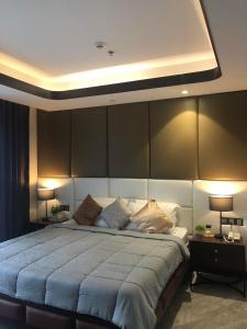 a bedroom with a large bed with two lamps at One Euphoria walking st Condotel Angeles city in Angeles