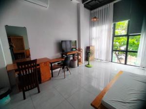 a living room with a television and a desk with a television at Kidona's House in Danang