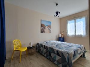 1 dormitorio con 1 cama y 1 silla amarilla en Maison L'Aiguillon-sur-Mer, 5 pièces, 7 personnes - FR-1-476-213, en LʼAiguillon-sur-Mer