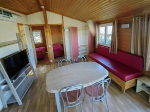 a room with a table and a couch and a tv at Chalet Agde, 3 pièces, 6 personnes - FR-1-607-194 in Agde