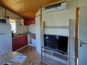 a small kitchen with a tv in a tiny house at Chalet Agde, 3 pièces, 6 personnes - FR-1-607-194 in Agde