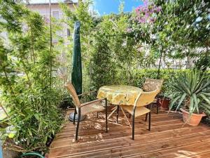 einen Tisch und Stühle auf einer Holzterrasse mit Pflanzen in der Unterkunft Appartement Amélie-les-Bains-Palalda, 2 pièces, 2 personnes - FR-1-703-178 in Amélie-les-Bains-Palalda